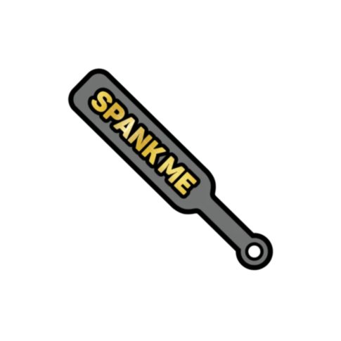Illustration of a Wood Rocket-Spank Me Paddle Pin, showcasing bold yellow lettering on its surface against a plain white background.