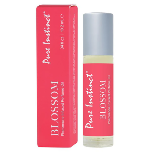 A pink box and a perfume roller bottle labeled Pure Instinct Blossom Pheromone Oil with Floral Elixir, featuring a silver cap.