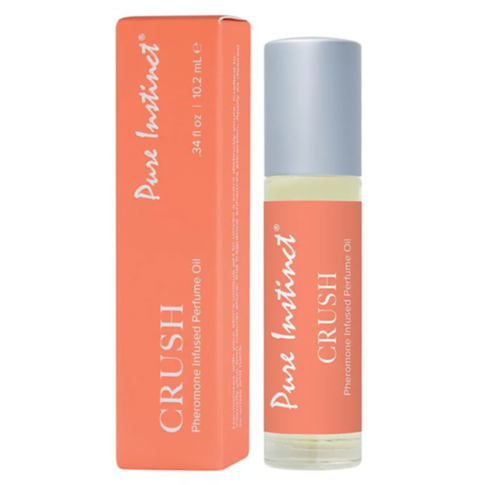 A bottle and box of Pure Instinct Crush Pheromone Oil, which boasts a seductive blend of amber and musk. The clear bottle, topped with a metal cap, is elegantly positioned next to its vibrant orange box adorned with white text, highlighting the fragrance'