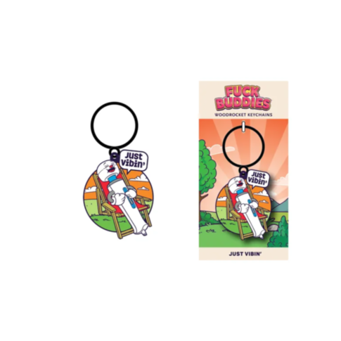 Introducing the Wood Rocket-Fuck Buddies-Just Vibin Keychain, an enamel accessory showcasing an astronaut on a swing with the words "Just Vibin." The packaging features a vibrant landscape of trees and mountains. This whimsical piece is perfect for those 