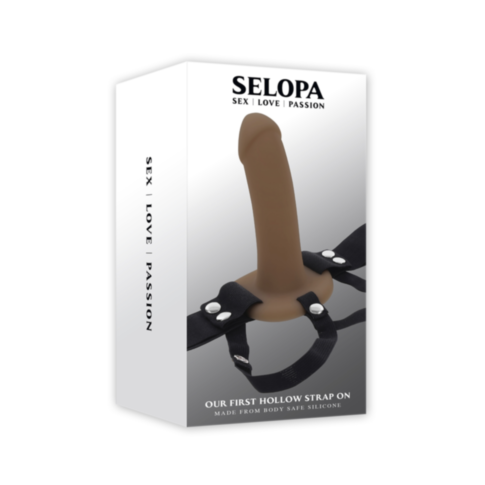 The packaging for the Evolved-Selopa Our First Hollow Strap On-Dark highlights its adjustable harness with black straps and metal buttons. Crafted from phthalate and latex-free silicone, it offers a safe and satisfying experience.