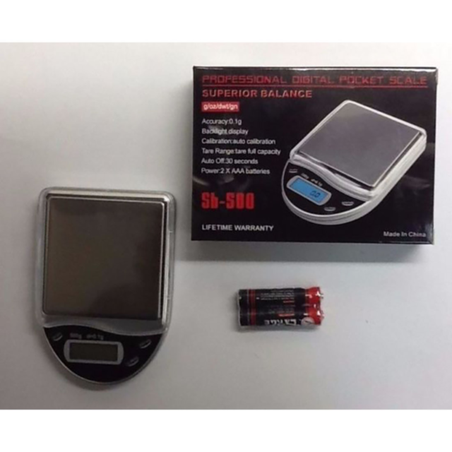 The SB 500 Scale 500g x 0.1g features a stainless steel platform and comes with its packaging box and two AAA batteries. It includes a backlight display for easy reading, ensures precise calibration, offers a lifetime warranty, and has a compact design wi