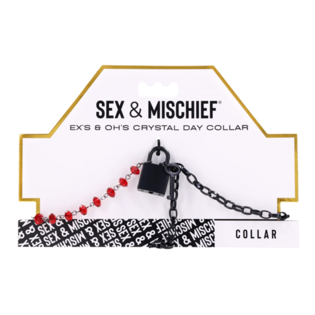 A package for Exs & Ohs Crystal Day Collar features a matte black chain, ruby red crystals, and a small black padlock. Collar appears in the bottom right corner.