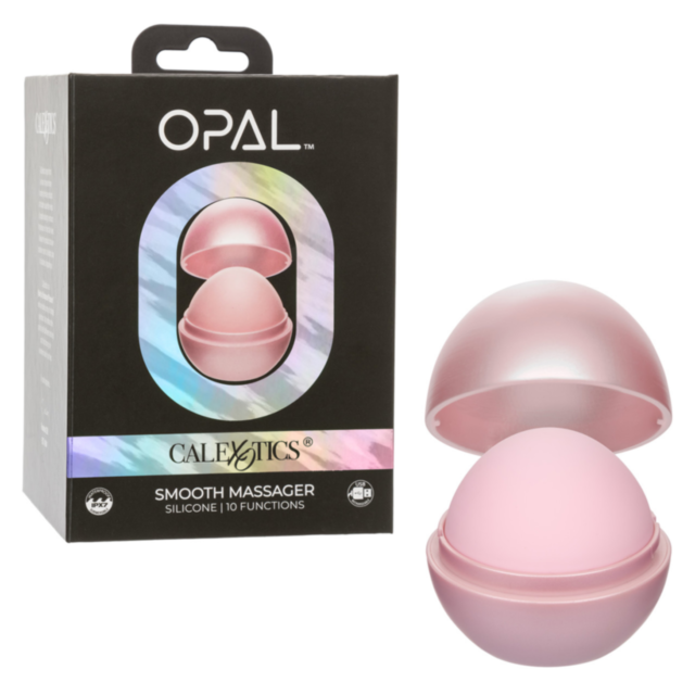 A small dog with dark fur and a red collar playfully chews on a stick while sitting on a light brown couch in a cozy living room, evoking the tranquility of the Cal Exotics-Opal Smooth Massager-Pink, known for its submersible design and body-safe silicone