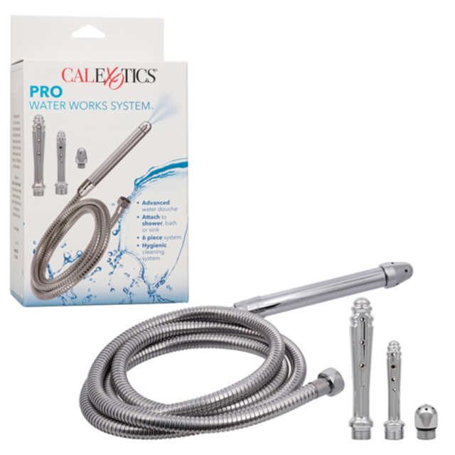 The Cal Exotics-Pro Water Works System is displayed boxed next to its contents: a flexible metal hose, a silver nozzle, and two interchangeable spray attachments for customizable hygienic cleaning.
