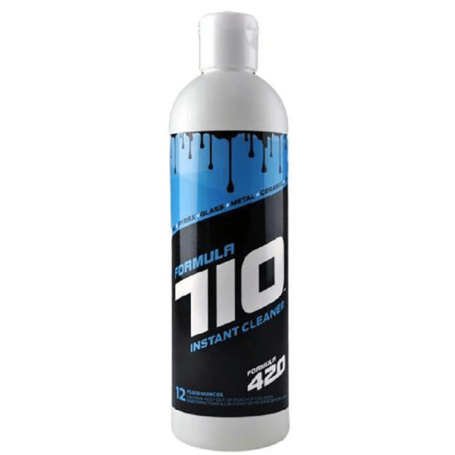 A cartoon rocket in a circular emblem, surrounded by stars, soars over a green background. The text "Formula 710 Instant Glass Cleaner 12oz" hovers at the top, hinting at the flawless impact of this non-abrasive cleaner.