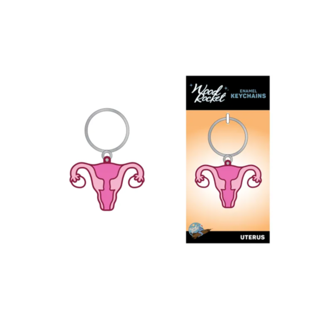Illustration of a pink uterus-shaped novelty accessory featuring a silver ring. Accompanying it, the packaging showcases the matching image with "Wood Rocket-Uterus Keychain" text, highlighting the allure of this unique enamel key ring.