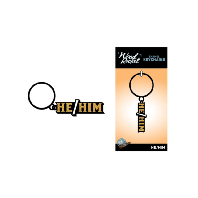 The Wood Rocket-He/Him Keychain is an enamel accessory featuring bold HE/HIM text in striking gold and black. The packaging displays the same keychain image with text at the bottom, set against a crisp white background.
