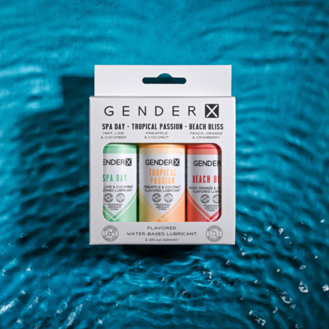 The image displays a circular logo depicting a rocket launching into space, with stars and a departing planet in the background. Set against a dark green backdrop, the words "Flavored Lube Travel Pack 2oz" are prominently highlighted, subtly suggesting an