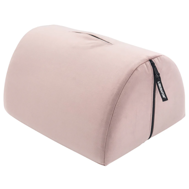 The Bonbon Microvelvet Liberty-Rose is a pink, dome-shaped footrest made from microvelvet, featuring a black zipper on one side. It boasts a soft, plush texture and includes a small handle on top. A fabric tag reading LEEPBROK is attached near the zipper,