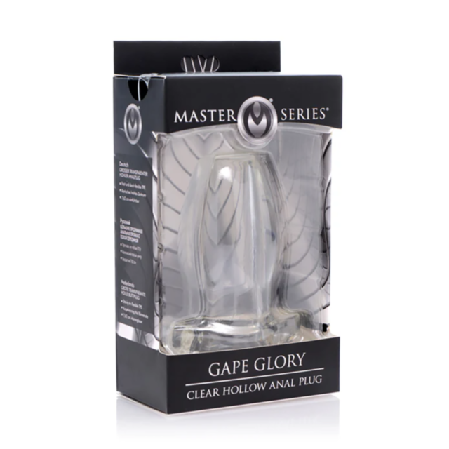 The image features the XR-Gape Glory Clear Hollow Anal Plug in its packaging. The product is a clear anal plug with a contoured base, and it is visible inside the black box, which has transparent sections to showcase the plug.