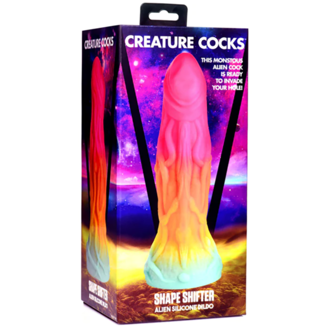 A no-image graphic showcasing the XR-Creature Cocks-Shape Shifter Alien Silicone Dildo, designed like a stylized rocket with three windows and an exhaust trail, made from phthalate-free silicone and surrounded by sparkles on a green backdrop.