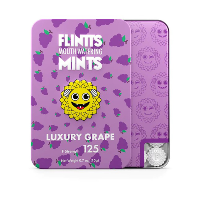A depiction of a rocket enclosed in a circular frame adorned with stars, placed against a green backdrop that evokes early-autumn warmth. The phrase "Flintt Mints Luxury Grape F Strength 125" is prominently featured at the top.