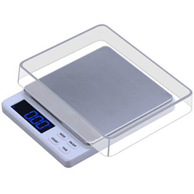 The Nitro 300 300x0.01g Scale boasts a stainless steel weighing platform and a transparent protective cover. Its display reads 0.00, with buttons for tare, mode, power, and unit adjustment, making it a sleek addition to any kitchen.